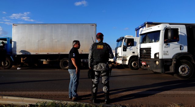 A police officer take position as they order truckers to clear the blocked BR-04 highway in Luziania, Brazil May 26, 2018. REUTERS/Adriano Machado