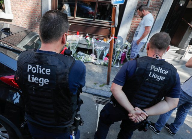 Los policías belgas rinden homenaje a las víctimas de un tiroteo en el exterior del café donde se produjo el tiroteo en Lieja, Bélgica, el 30 de mayo de 2018. REUTERS / Yves Herman
