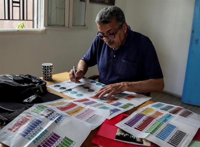 (LÍBANO), 03/05/2018.- Un ciudadano libanés inspecciona listas de candidatos hoy, jueves 3 de mayo de 2018, durante las campañas para las elecciones parlamentarias libanesas, en Beirut (Líbano). Un total de 976 candidatos, incluidas 111 mujeres, presentaron sus documentos de candidatura al Ministerio del Interior, lo que representa la mayor cantidad de candidatos jamás registrados. Las elecciones generales del 06 de mayo de 2018 serán las primeras del Líbano en nueve años. EFE/Nabil Mounzer