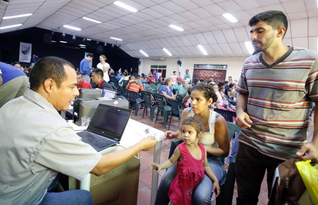 CUC05. CÚCUTA (COLOMBIA), 04/05/2018.- Un grupo de venezolanos recibe asistencia en Cúcuta (Colombia) este 3 de mayo de 2018. Bajo el sol intenso de la ciudad colombiana de Cúcuta, cientos de familias venezolanas que huyeron de su país por la crisis económica y política hacen fila para reclamar los bonos alimentarios que entrega el Programa Mundial de Alimentos (PMA) de la ONU en las zonas de frontera. El proyecto que comenzó este lunes en Cúcuta, capital de Norte de Santander, surge como la primera gran respuesta de la comunidad internacional al delicado estado alimentario del 90 % de los cerca de 35.000 venezolanos que cruzan a diario las fronteras con Colombia en busca de oportunidades. EFE/SCHNEYDER MENDOZA