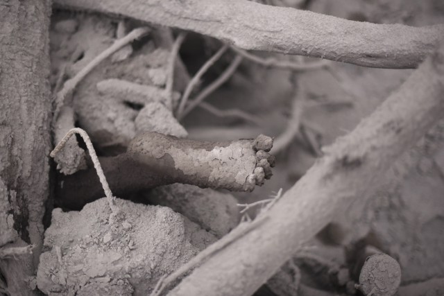 Imagen de los pies de una víctima de la erupción del volcán Fuego en San Miguel Los Lotes, un pueblo en el departamento de Escuintla, a unos 35 km al suroeste de Ciudad de Guatemala, el 4 de junio de 2018. Al menos 25 personas murieron, según el Coordinador Nacional de Reducción de Desastres (Conred), cuando el volcán Fuego de Guatemala entró en erupción el domingo, eructando ceniza y roca y obligando al aeropuerto a cerrarse .. / AFP PHOTO / Johan ORDONEZ