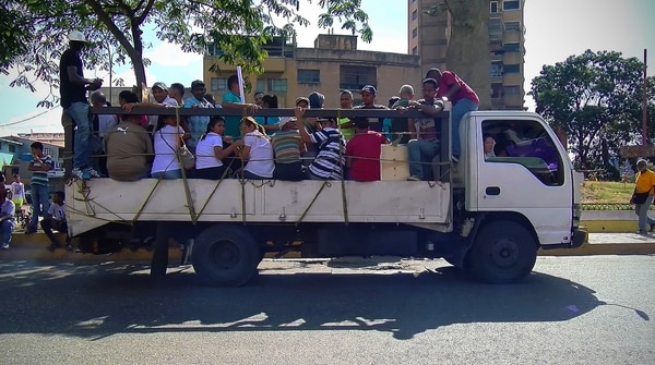 Las cajas de diferentes tipos de camiones y pick ups se han vuelto un transporte informal habitual en las calles de las principales ciudades venezolanas (foto infobae.com)