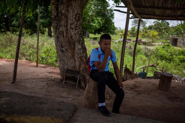 Fotografía fechada el 10 de mayo de 2018 que muestra a un niño de la etnia Warao mientras espera por una unidad de transporte, en Maturín (Venezuela). Unos 120 indígenas distribuidos en cerca de 30 palafitos de precaria elaboración conforman la comunidad de Morichal Largo, un asentamiento de la etnia Warao ubicado en el sur de Venezuela, que resiste debajo de un puente la miseria e insalubridad propia de la crisis nacional. EFE/Cristian Hernández