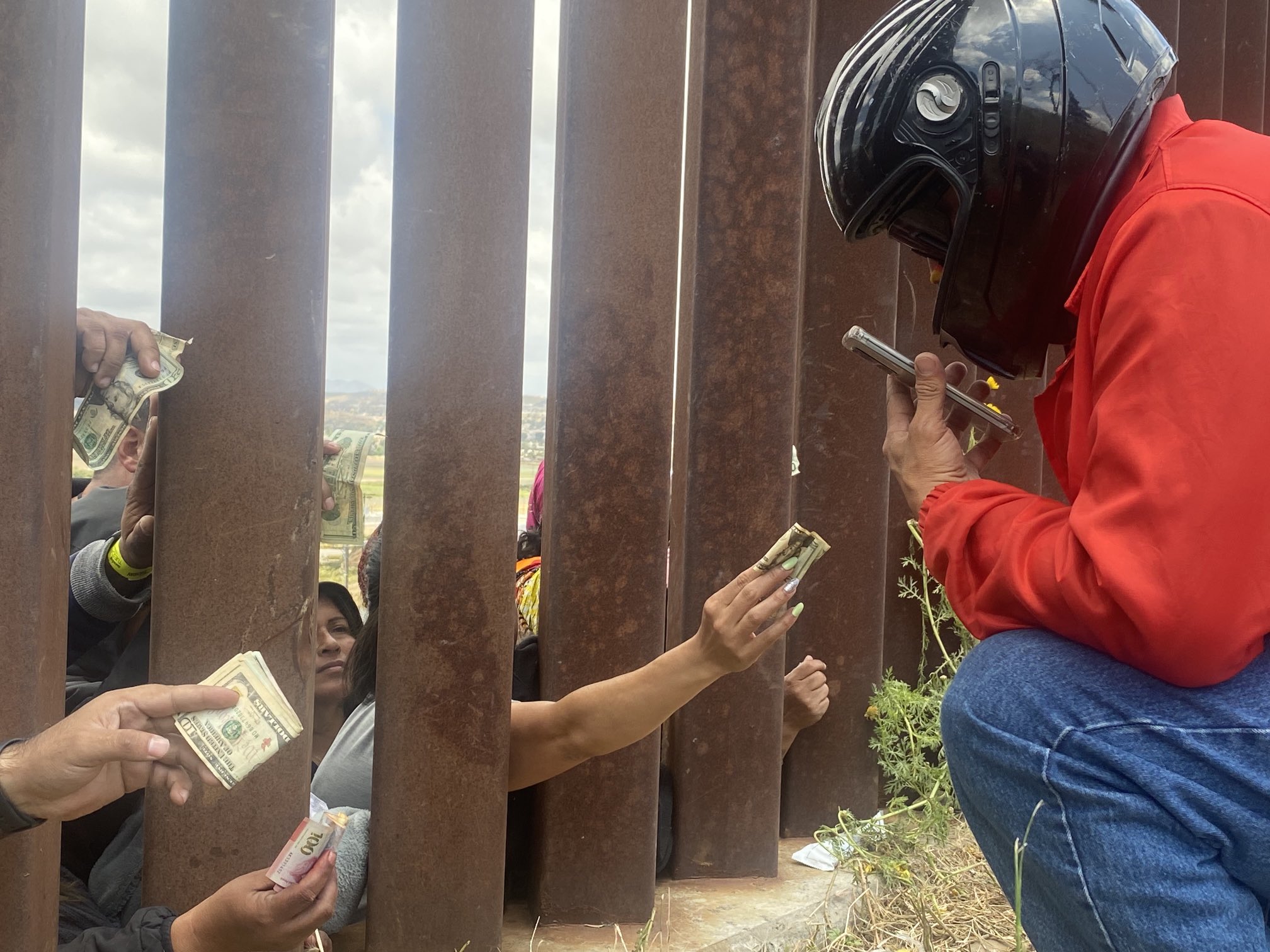 Dramático VIDEO: migrantes pagan altas sumas a repartidor por ración de pollo al pie del muro